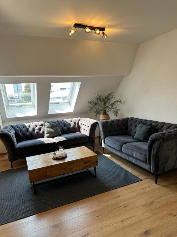 un salon avec deux canapés et une table basse dans l'établissement A&A Apartment, à Oftringen