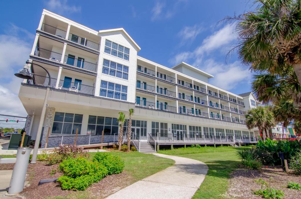 an exterior view of a building with palm trees at Ocean Escape Boardwalk Oceanfront in Myrtle Beach