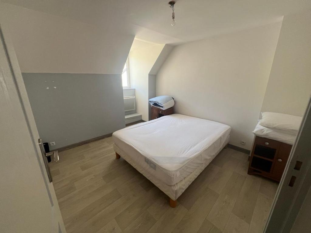 una piccola camera con letto bianco e pavimenti in legno di Chez Burons&Bouchons, Le Refuge Gourmand et Authentique a Condat