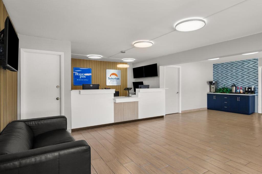 an office lobby with a couch and a counter at Suburban Studios Orange Park - Jacksonville near Naval Air Station in Orange Park