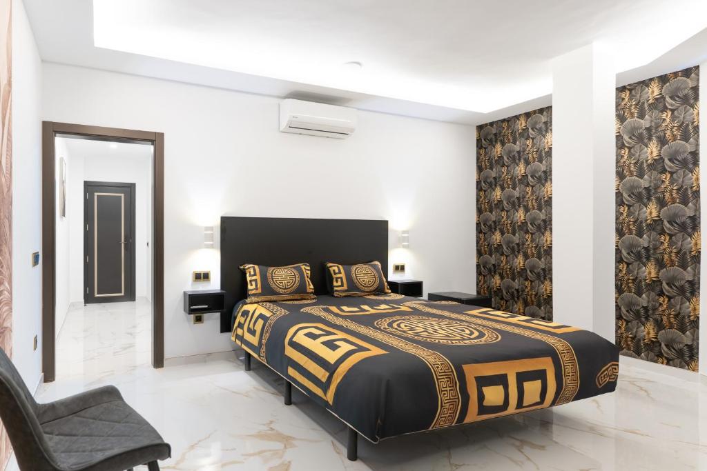 a bedroom with a king sized bed and a chair at HH Riz Resort - Adults Only in Maspalomas