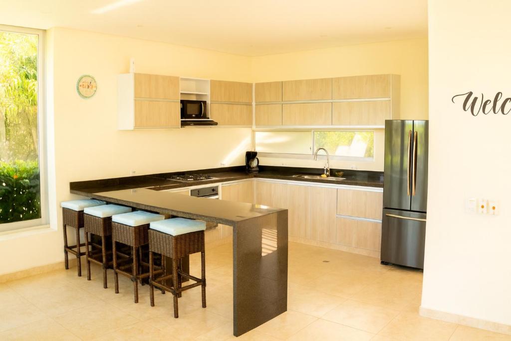a kitchen with a black counter top and a refrigerator at Casa Familiar con Piscina, BBQ, Bicicletas in Anapoima