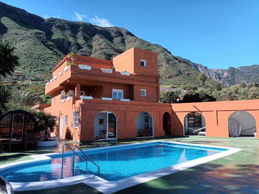 a house with a swimming pool in front of a mountain at Finca Rosa in Güimar