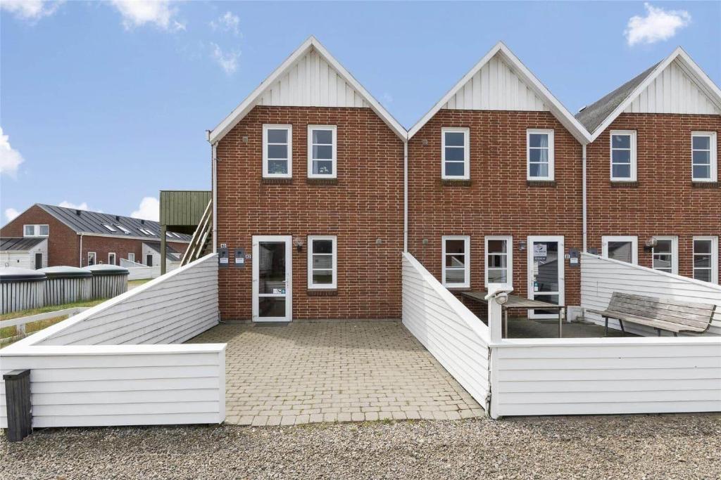 un edificio de ladrillo con un banco delante de él en 0423-Romo-Vestergade-231-Ap-82, en Sønderby