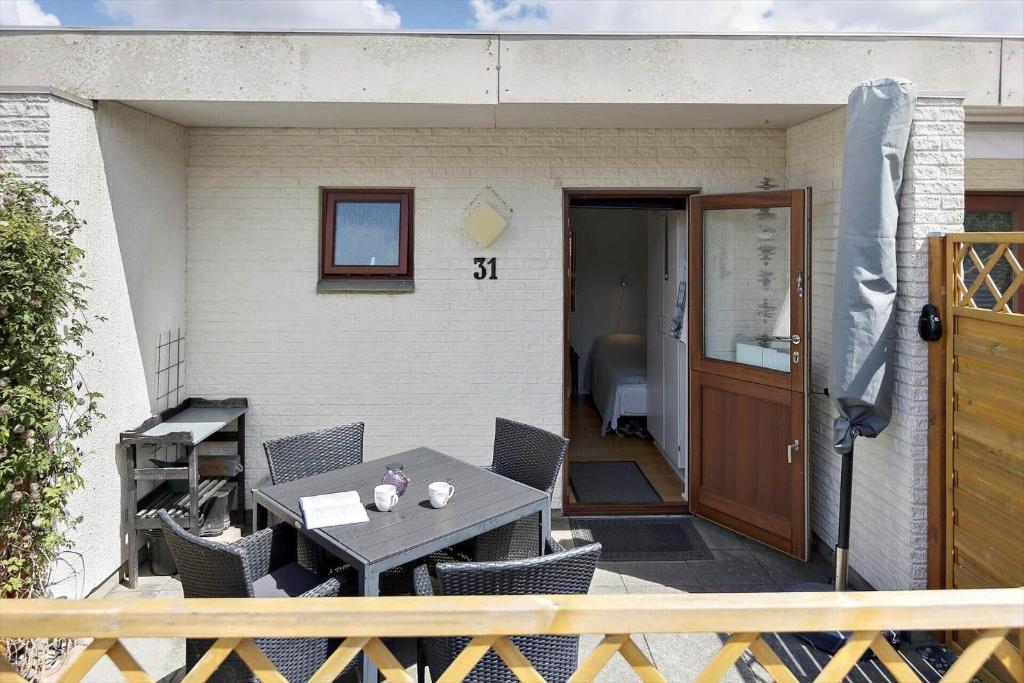 ロモ・キルケビーにある0268-Romo-Lyngvejen-99-Ap-31のテーブルと椅子とドアのあるパティオ