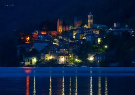a view of a city at night with the water at Casa Caterina in Dervio
