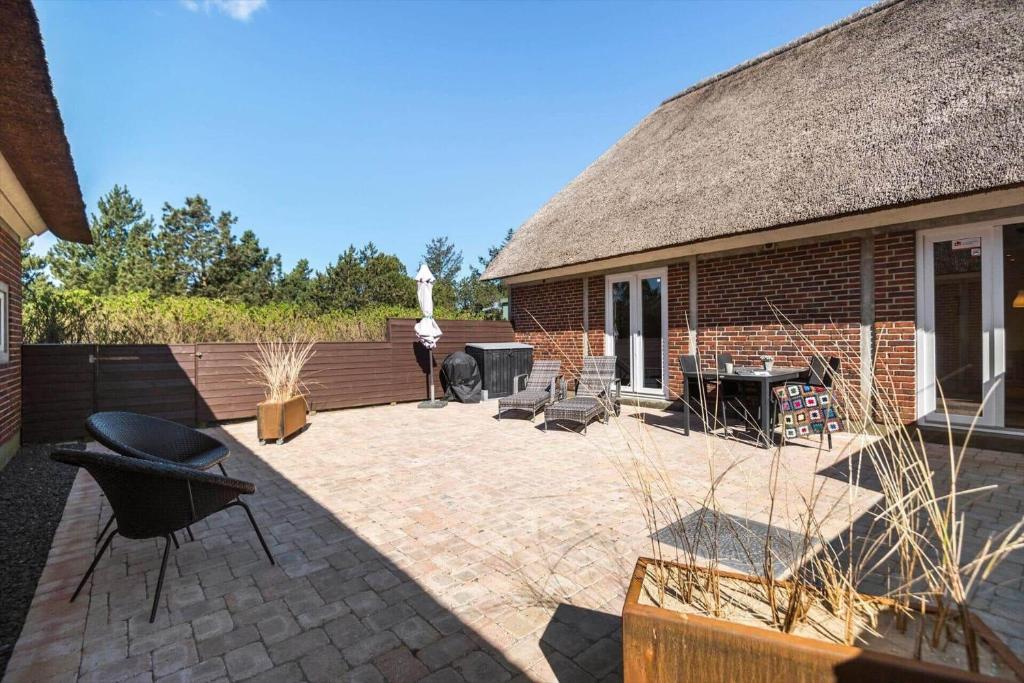 un patio di una casa con un tetto di paglia di BV230-Blavand-Vesterhavsparken-35 a Blåvand