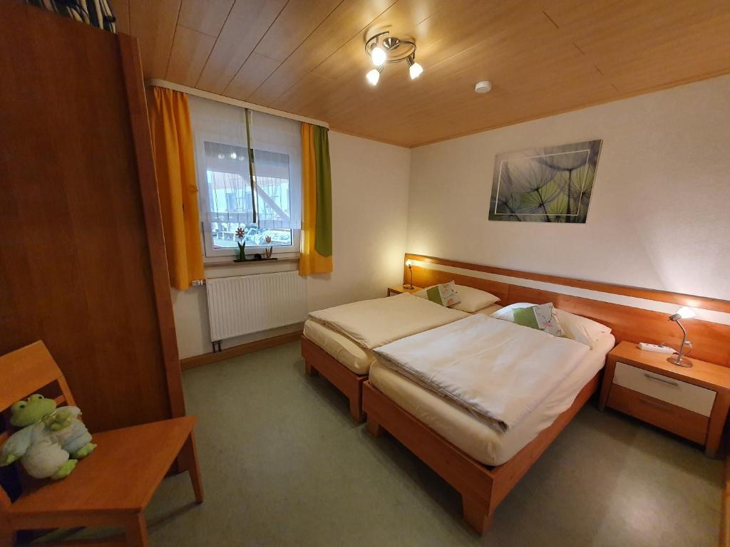 a bedroom with a bed and a table and a window at Rennerhof-Siebeneichen Fewo Laubfrosch in Sulzbach-Rosenberg