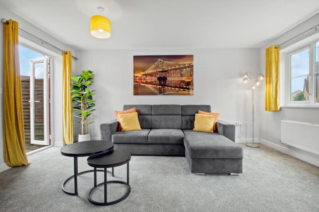un soggiorno con un divano e un tavolo di Spacious 3-Bed House with Parking and Garden ad Aylesbury