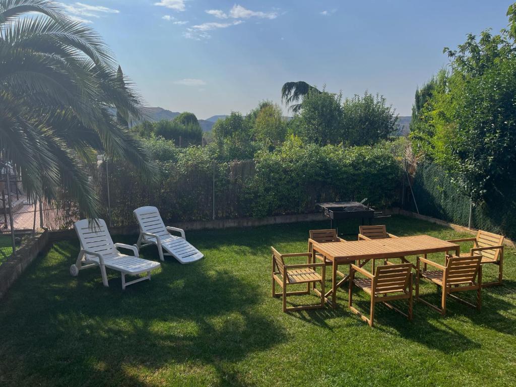 a backyard with a table and chairs and a grill at Las Candelas, Casa Turística in Uruñuela