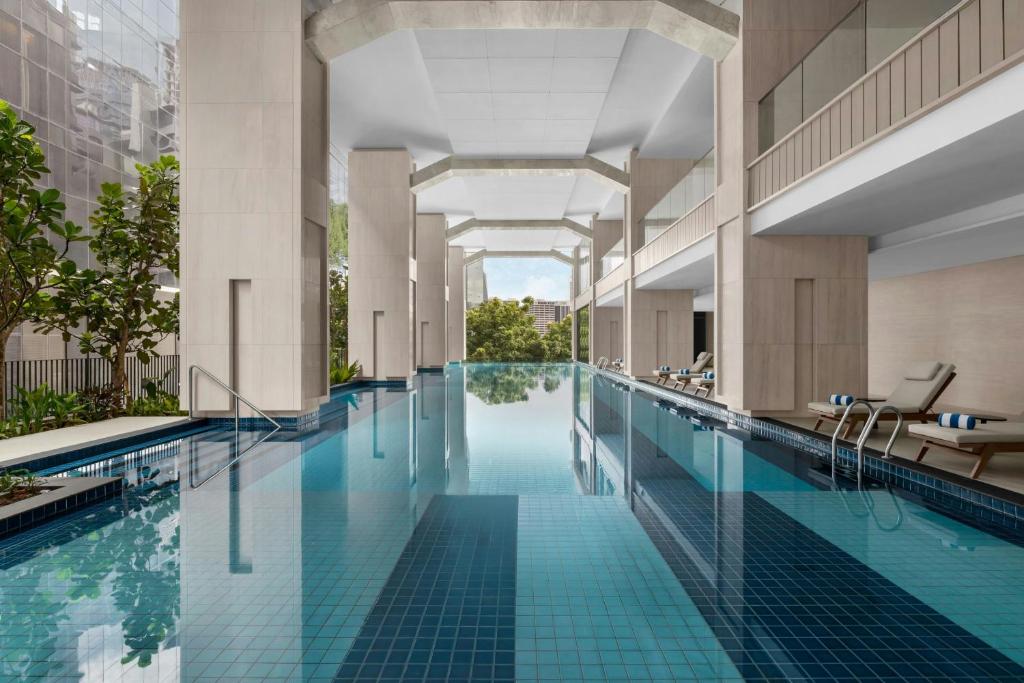 a swimming pool in a building with blue tiles at Marriott Executive Apartments Kuala Lumpur in Kuala Lumpur