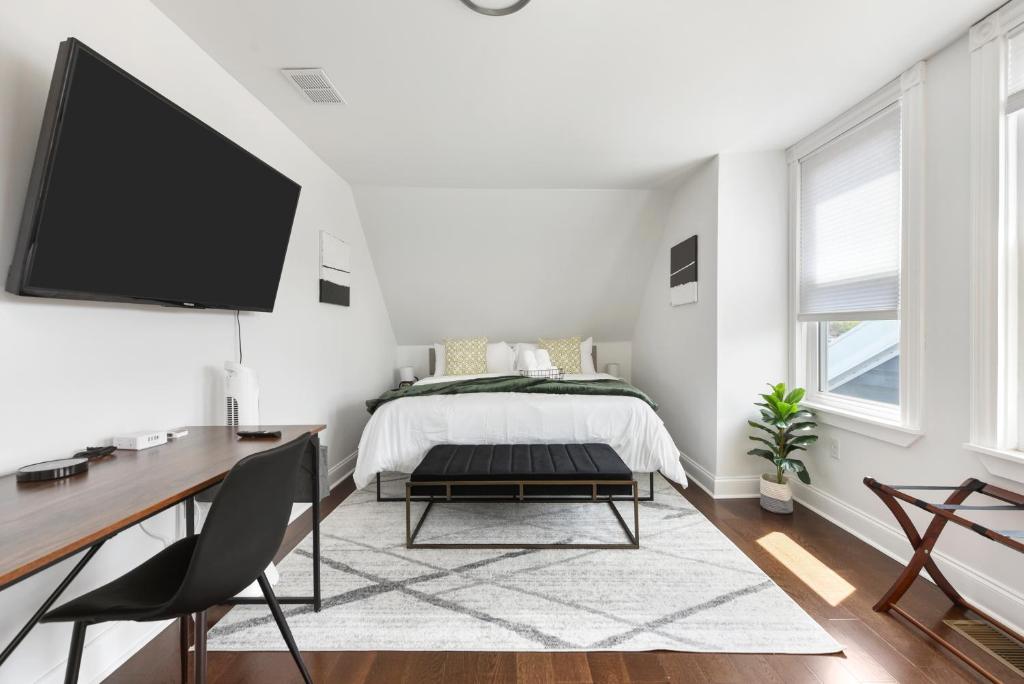 a bedroom with a bed and a desk and a tv at The Point State Room on Beatty in Pittsburgh