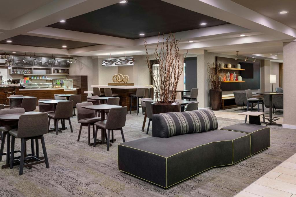 a lobby with tables and chairs and a cafeteria at Courtyard St. Louis Airport/Earth City in Bridgeton