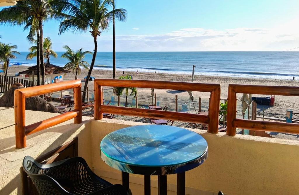 a table on a balcony overlooking the beach at Apto 206 Frente Mar Elegance Flat in Natal