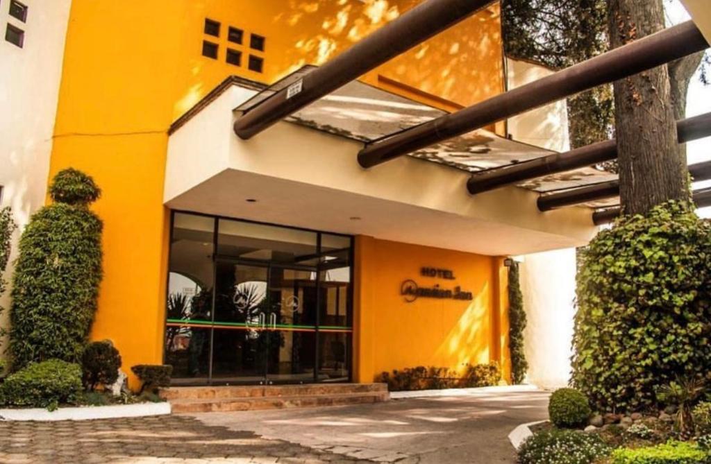 a store front with yellow walls and windows at Hotel y centro de convenciones MANSION INN in San Mateo Texcalyacac