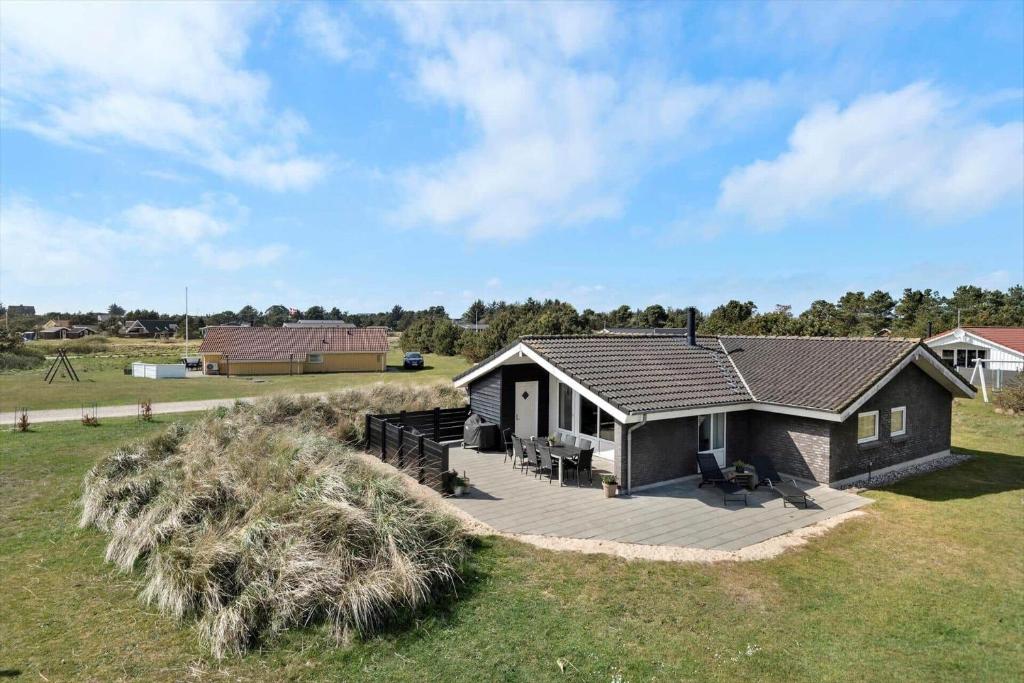 a small house with a deck in a field at BV117-Vejers-Strand-Engesovej-34 in Vejers Strand