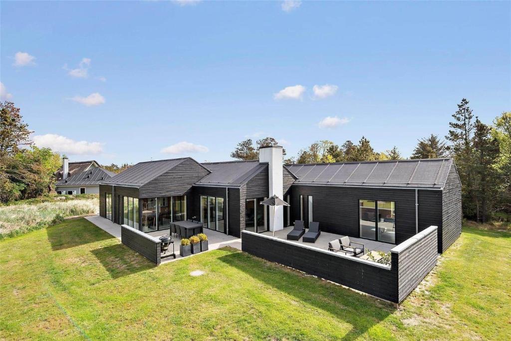 a black house with a large yard at BV186-Blavand-Lyngsletten-41 in Blåvand