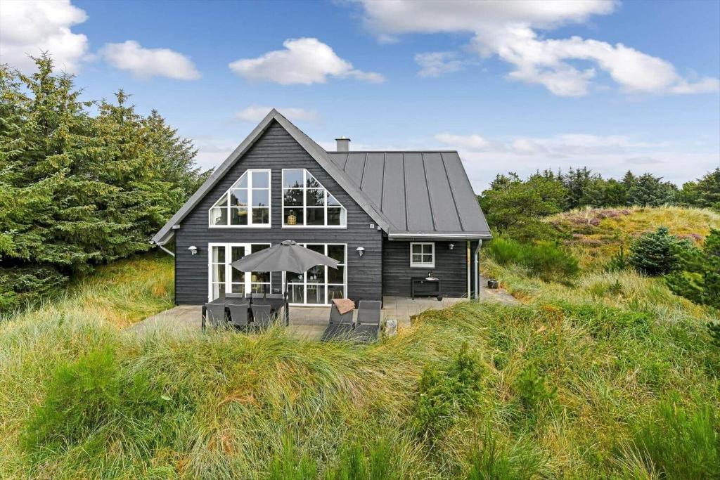 a black house sitting on top of a hill at BV374-Blavand-Krogsande-22 in Blåvand