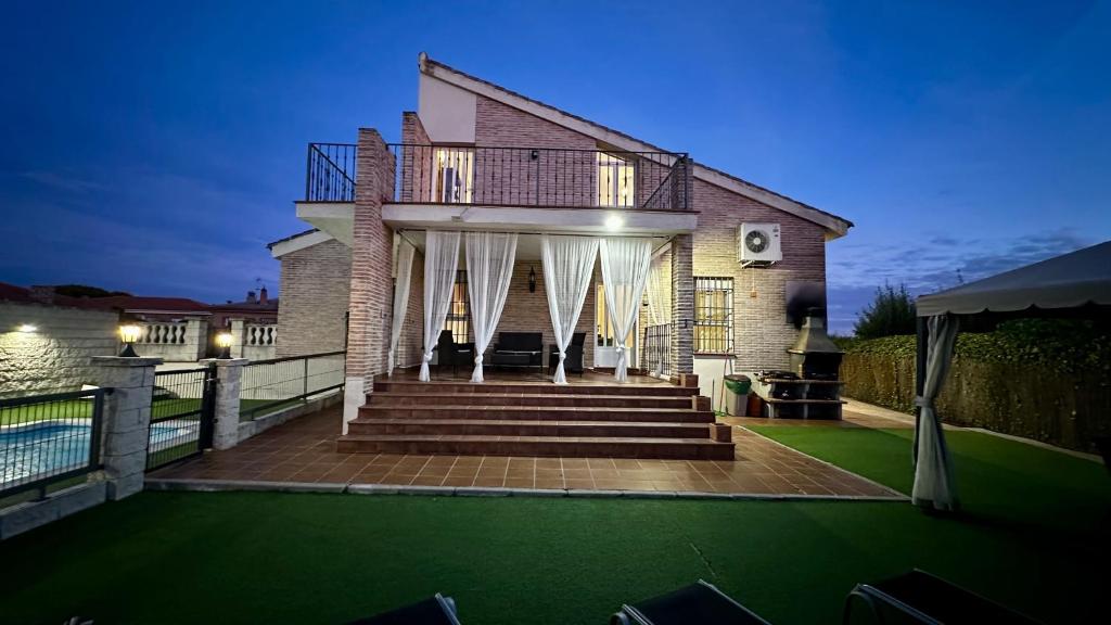 a house with a deck with a green lawn at Casa nardo alojamiento rural in Argés
