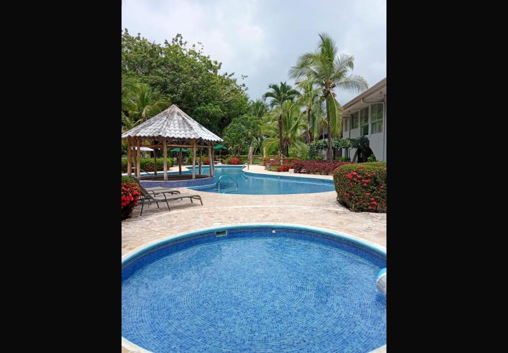 a pool with a gazebo and a resort at Modo relax Quepos in Quepos