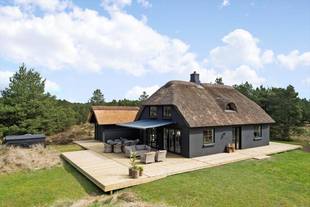 a large black house with a thatched roof at BV264-Blavand-Solhaven-47 in Blåvand