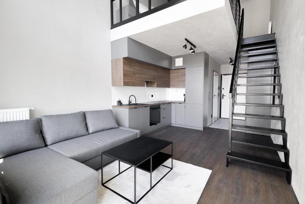 a living room with a couch and a kitchen at Sea Loft 49 in Gdynia