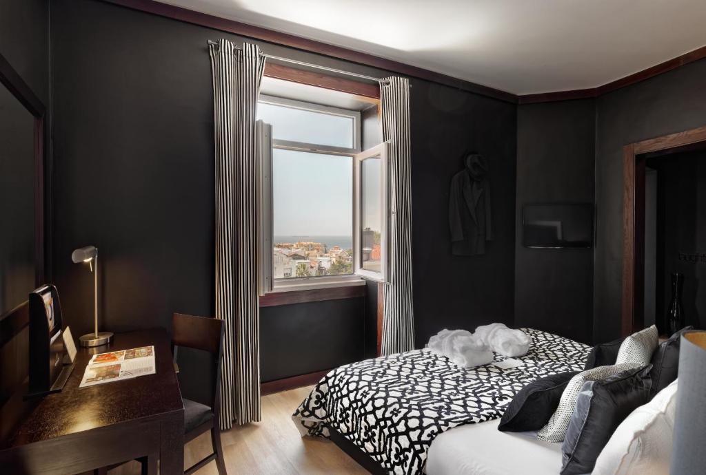 a bedroom with a bed and a window at Hotel Inglaterra - Charme & Boutique in Estoril