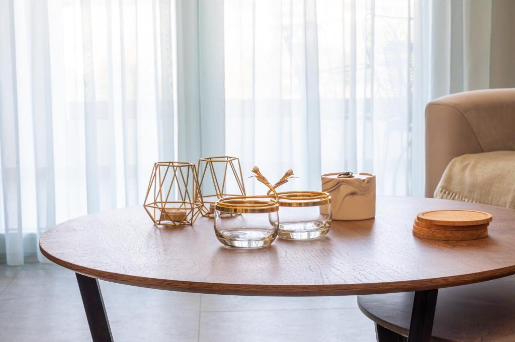 a wooden table with four glass bowls on it at The Circle Point Apartment in Larisa