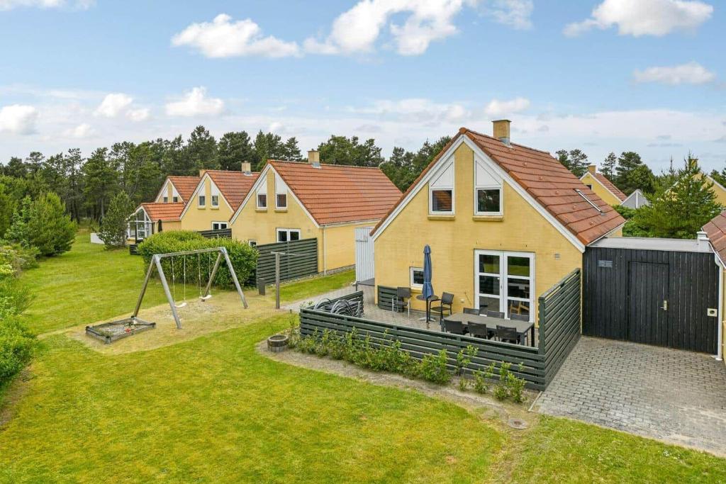 a house with a playground and a swing at BV348-Blavand-Fyrgarden-19 in Blåvand