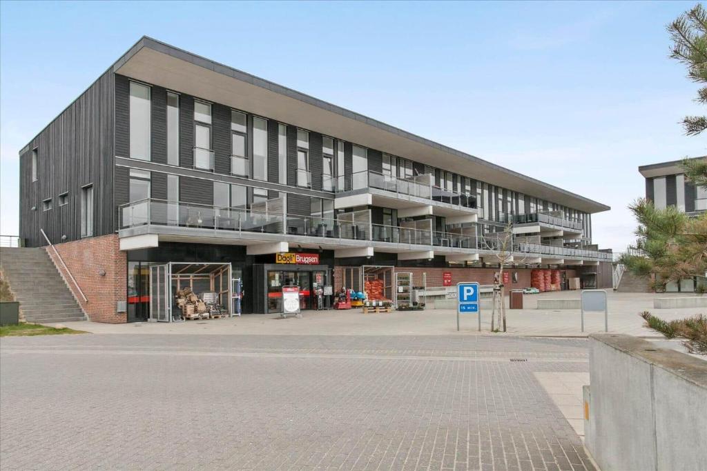 een groot zwart gebouw met balkons aan een straat bij 0387-Romo-Nordre-Havnevej-18 in Havneby