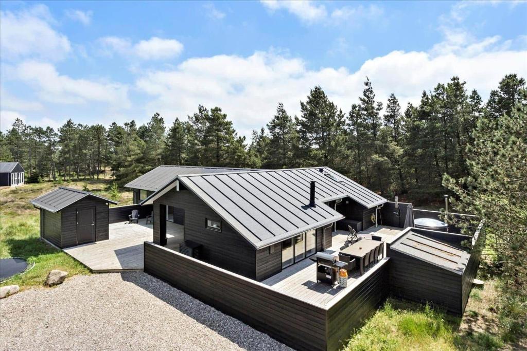 een zwart huis met een terras en een grill bij 0200-Romo-Elmegardsvej-10 in Tagholm