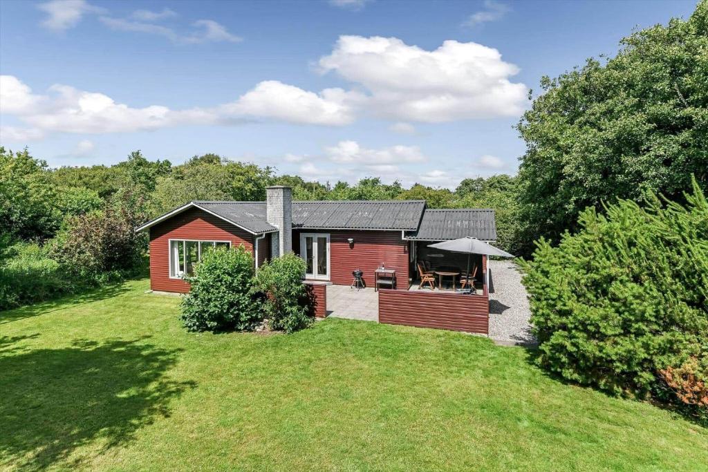 a small red house on a grass field at BV310-Blavand-Gronnevej-16 in Blåvand