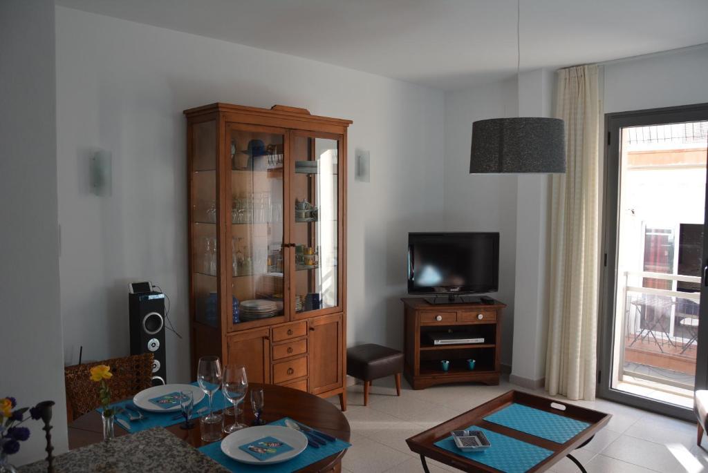 a living room with a wooden cabinet and a television at Apartamento Flavia I Espalter in Sitges