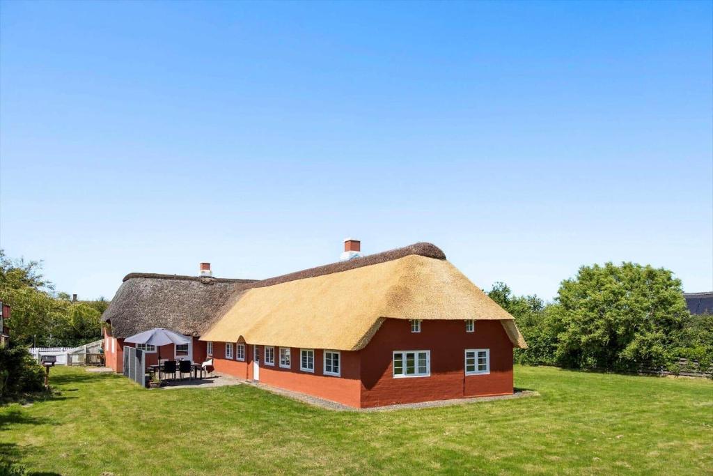 a red house with a thatched roof on a field at 2001-Romo-Juvrevej-80 in Høm