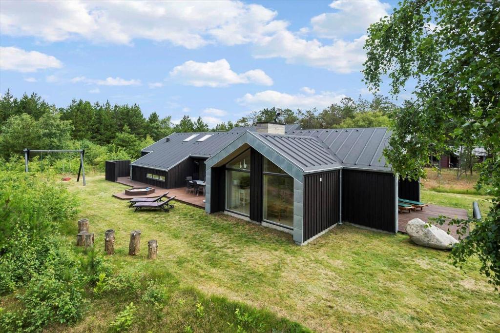 a black house with a roof on a yard at 0399-Romo-Strandskaden-22 in Høm