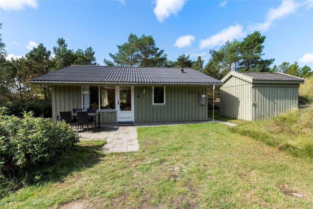 a small green house with a patio at 0215-Romo-Vestergardsvej-8 in Høm