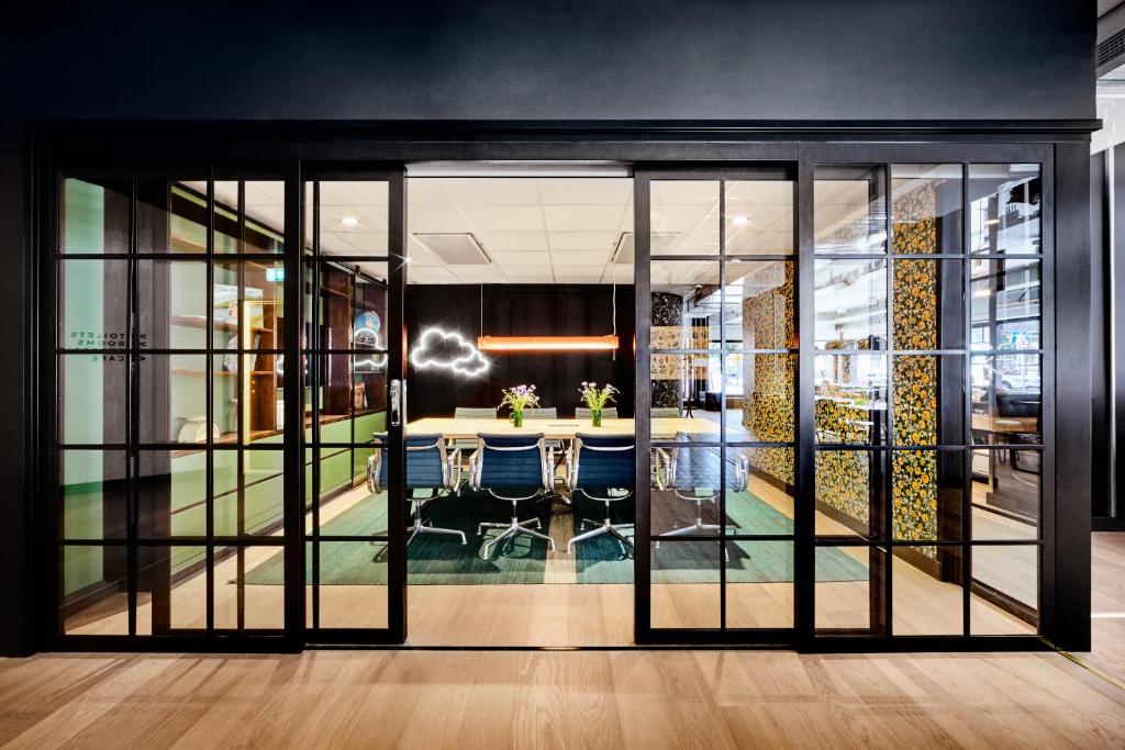 an office with glass doors and a table with blue chairs at Generator Stockholm in Stockholm