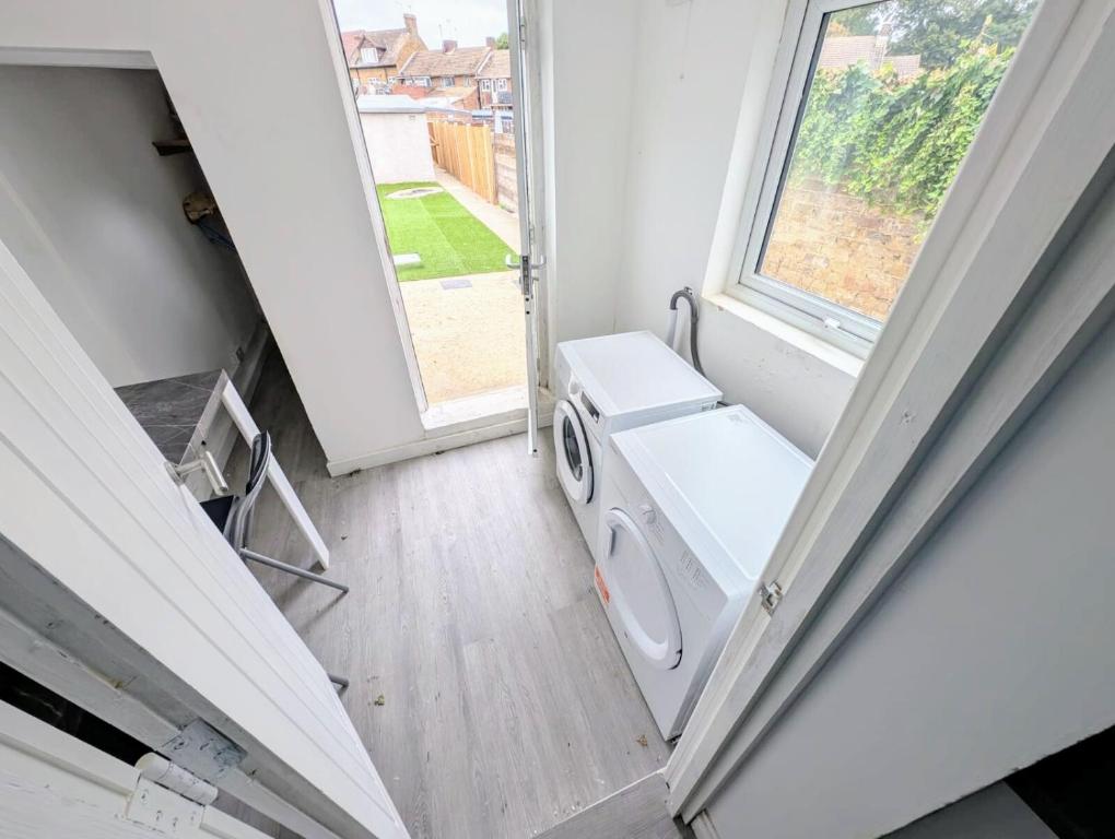 a laundry room with a washing machine and a window at Chic En-suite Room with Office Garden and Parking New Renovation in Wainscot