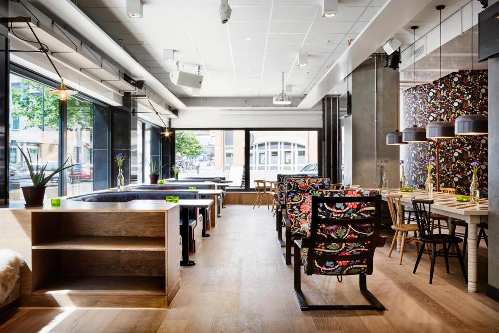 a restaurant with tables and chairs and windows at Generator Stockholm in Stockholm