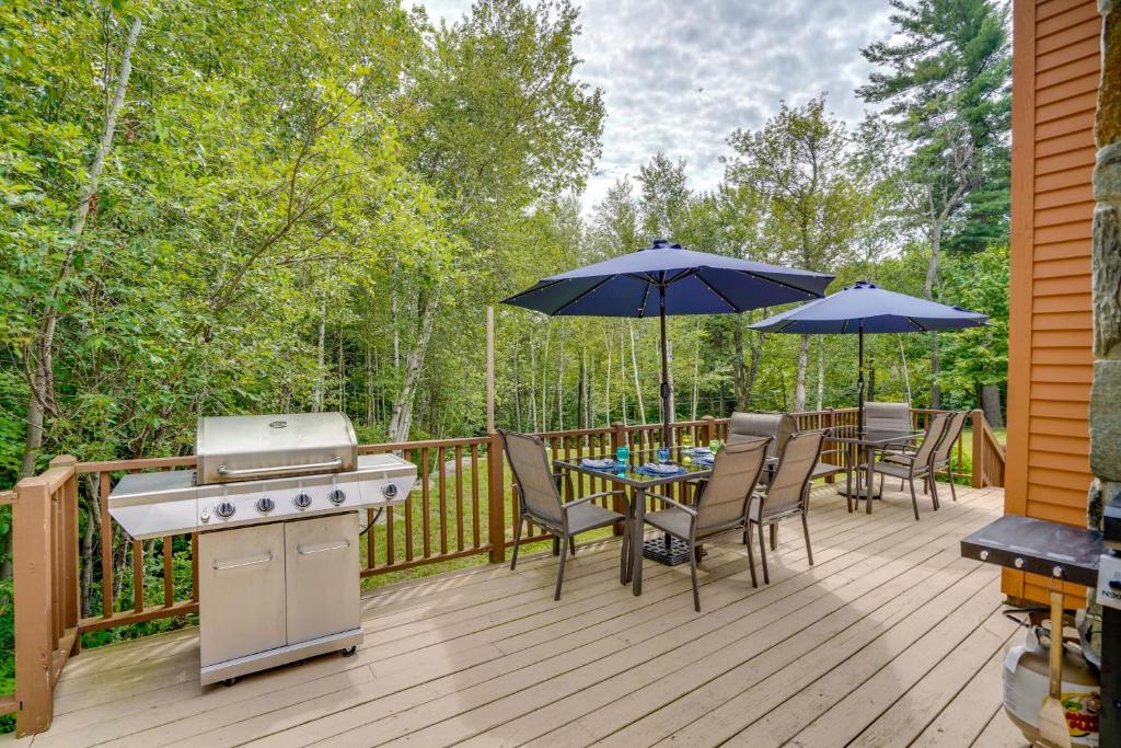 a deck with a grill and tables and umbrellas at Game Room, Hot Tub! Year-Round Dover Retreat in West Dover