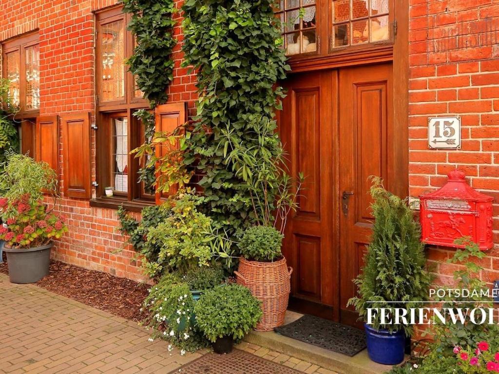 a brick building with a red door and some plants at Apartment in the Dutch Quarter in Potsdam