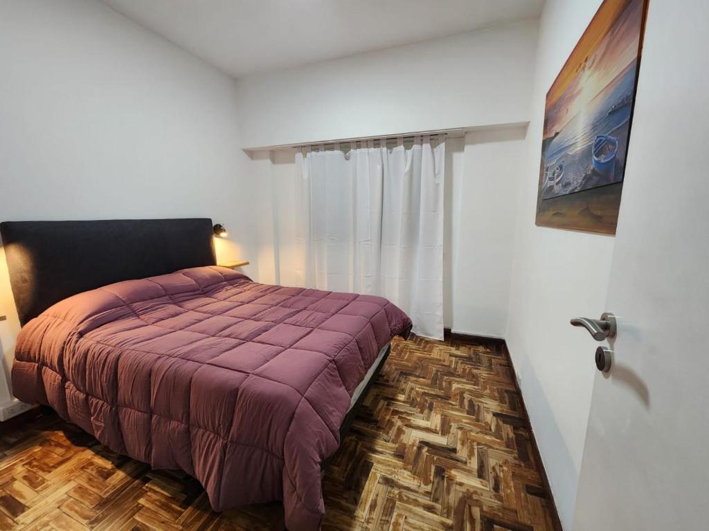 una camera con un letto e una coperta viola di Dpto zona Güemes 2 amb con balcón a Mar del Plata