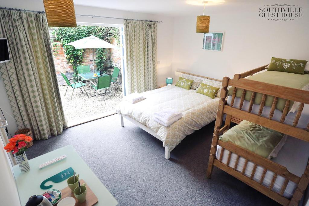 a bedroom with a bed and a balcony with a table at Southville Guest House in Bristol