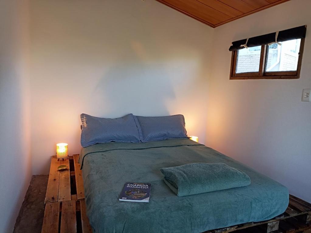 a bedroom with a bed with two lamps and a book at Vista do Sincorá in Ibicoara