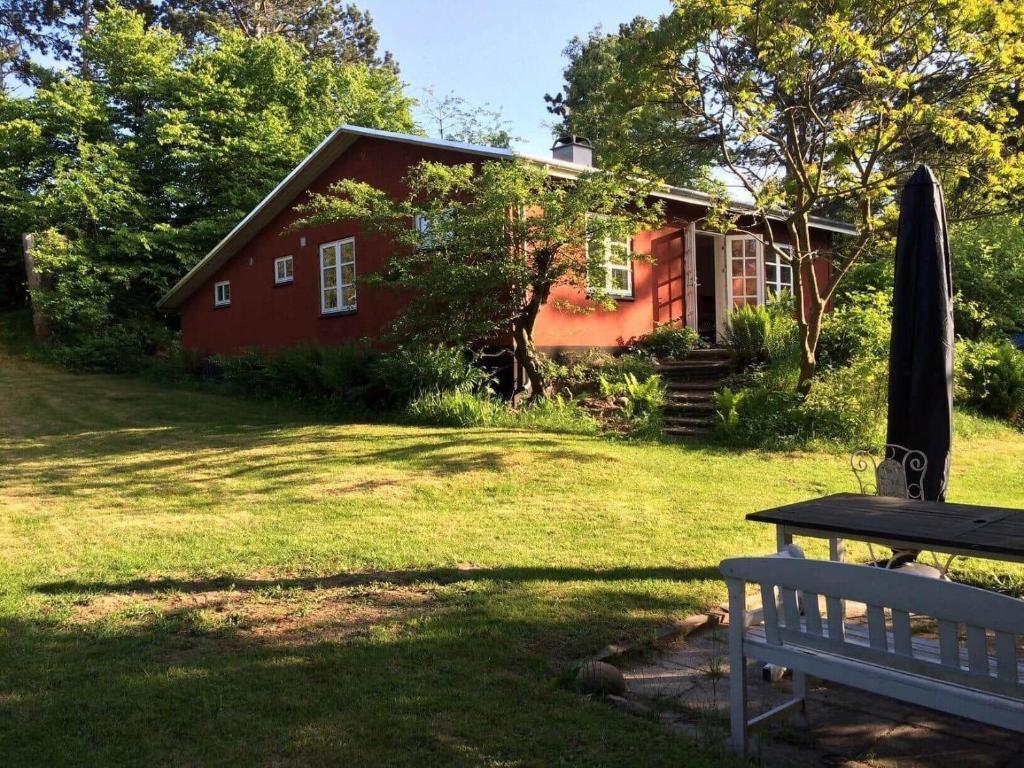 a red house with a bench in front of it at 15505-Farevejle-Tjornebakken-9 in Fårevejle