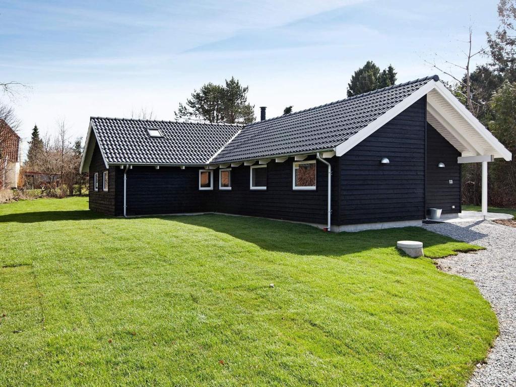 a black house with a large yard in front of it at Luxury Retreat in Hornbaek - By Traum Ferienwohnungen in Hornbæk