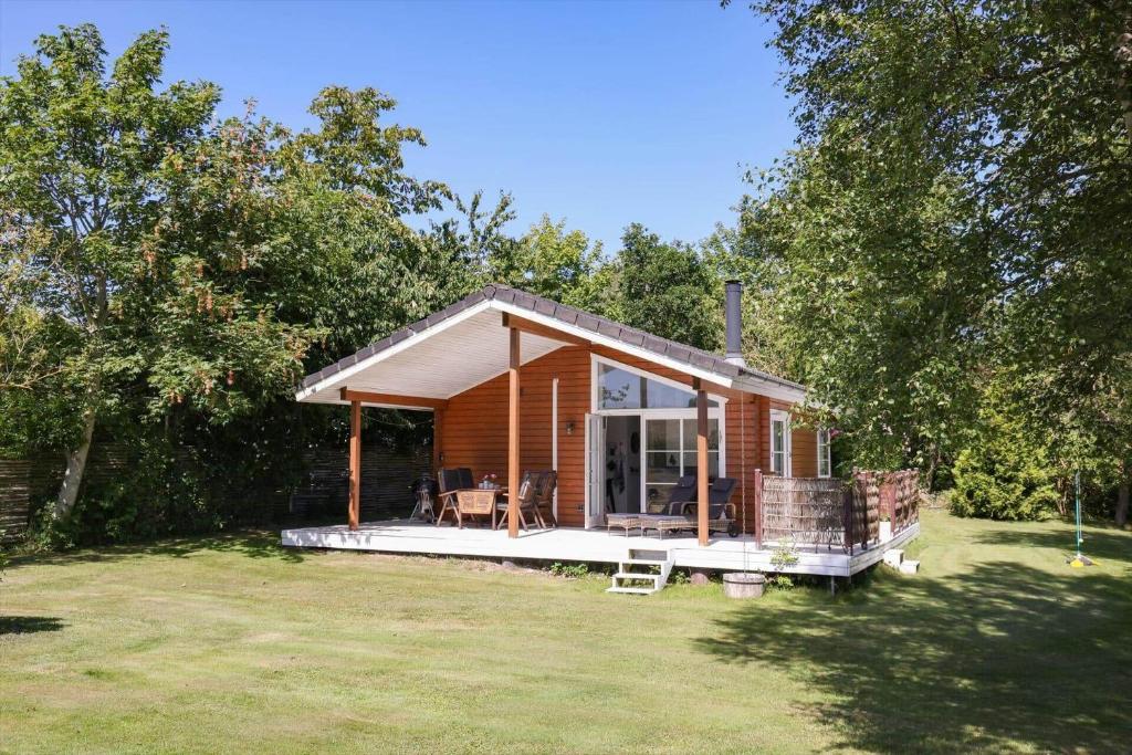 a small house with a large deck in a yard at 14235-Grevinge-Askebjerggardsvej-20 in Grevinge