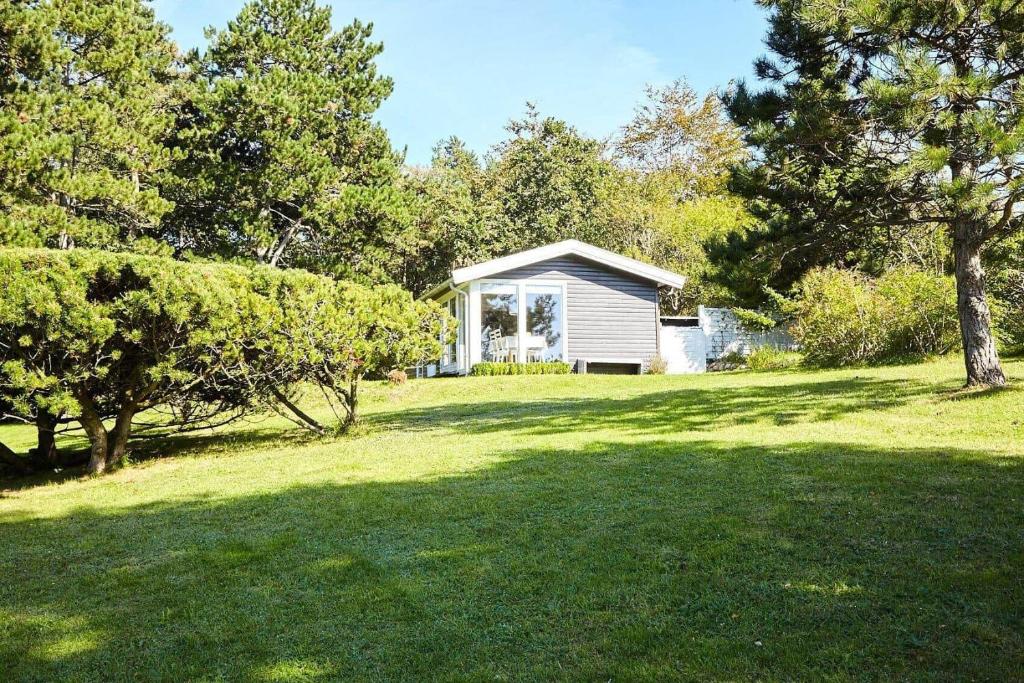 a small white house in a field with trees at 15524-Farevejle-Lynghoj-5 in Fårevejle
