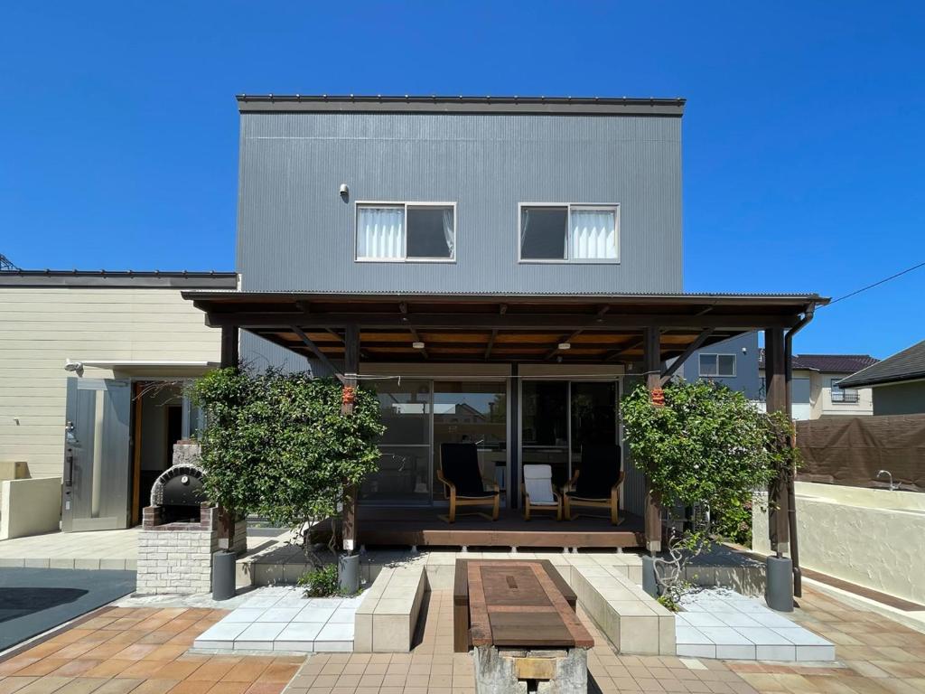 a house with two chairs on a patio at Sauna and BBQ Motosuka Beach Amansuka-サウナ&BBQ 本須賀ビーチAmansuka in Sammu