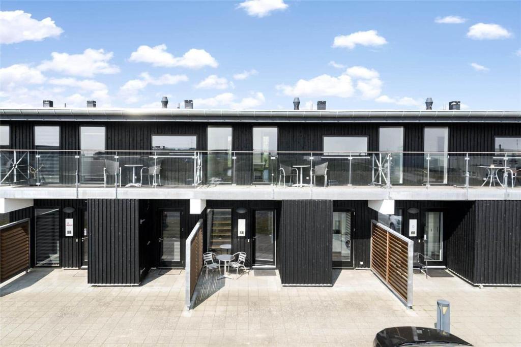 un edificio con balcón con mesas y sillas en 0427-Romo-Nordre-Havnevej-58, en Havneby